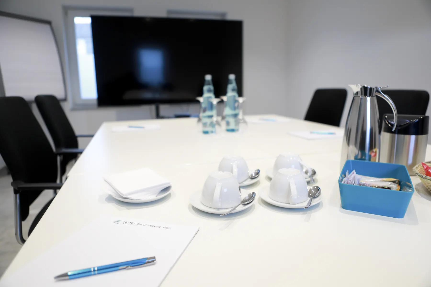 Coffee cups and a pen on a meeting table