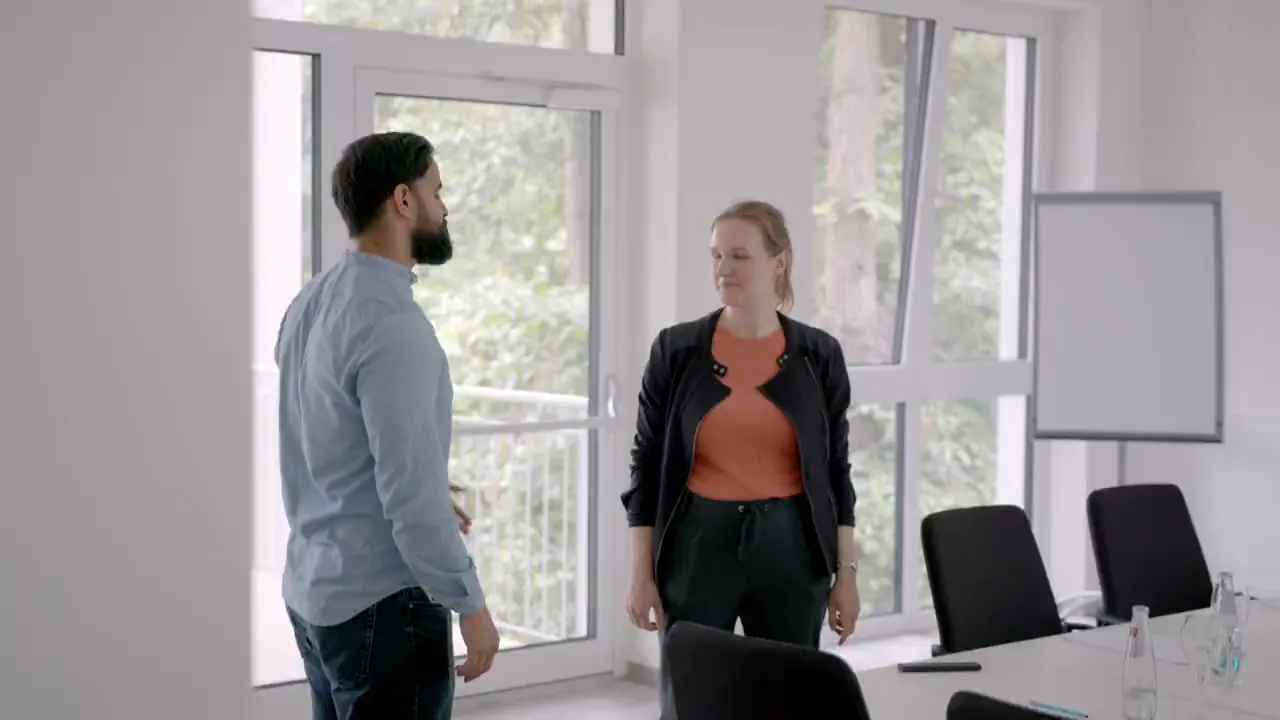 Two people talking in a bright meeting room